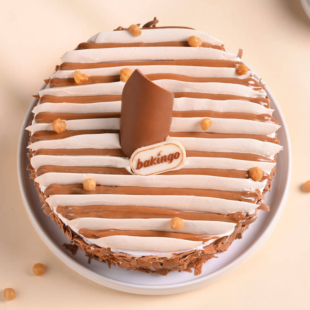 Butterscotch Crunch Cake With Floral Rakhi Top View of Butterscotch Crunch Cake With Floral Rakhi