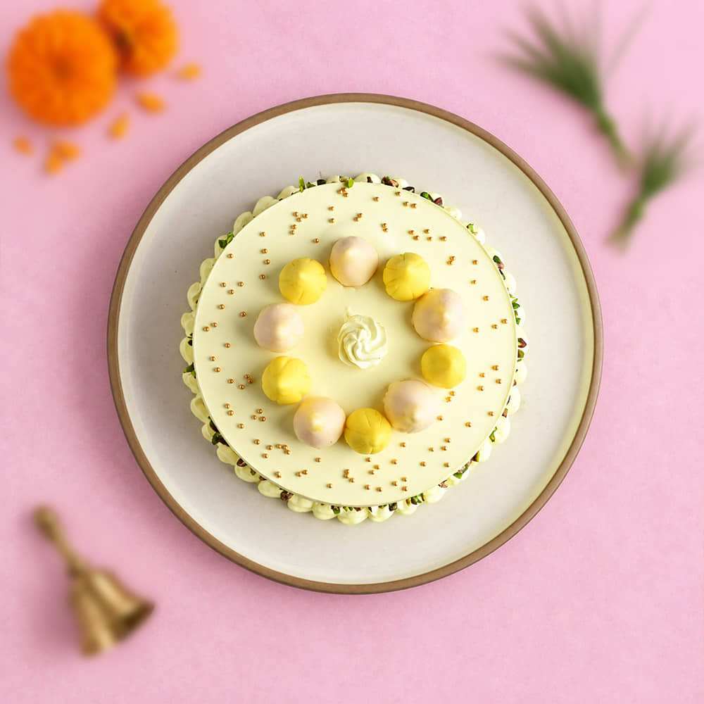 top view Pistachio Coated Butterscotch Modak Cake topped with dry fruits top view Pistachio Coated Butterscotch Modak Cake topped with dry fruits