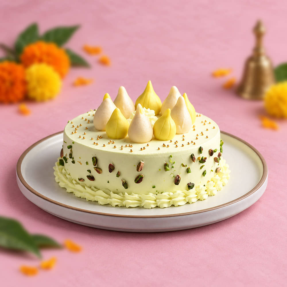 side view Pistachio Coated Butterscotch Modak Cake topped with dry fruits side view Pistachio Coated Butterscotch Modak Cake topped with dry fruits